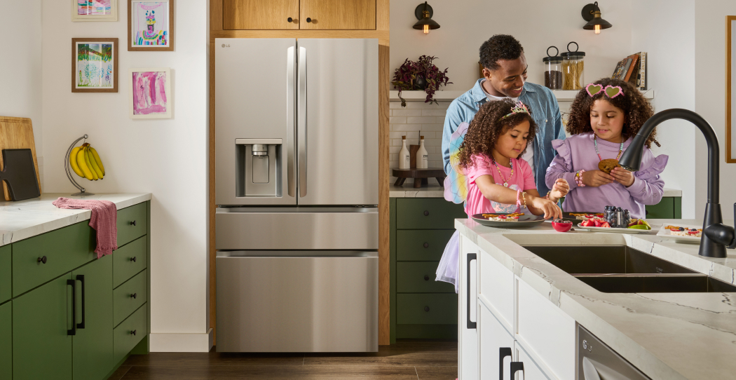 photo of a built-in refrigerator in a kitchen with wooden floors and green cabinetry